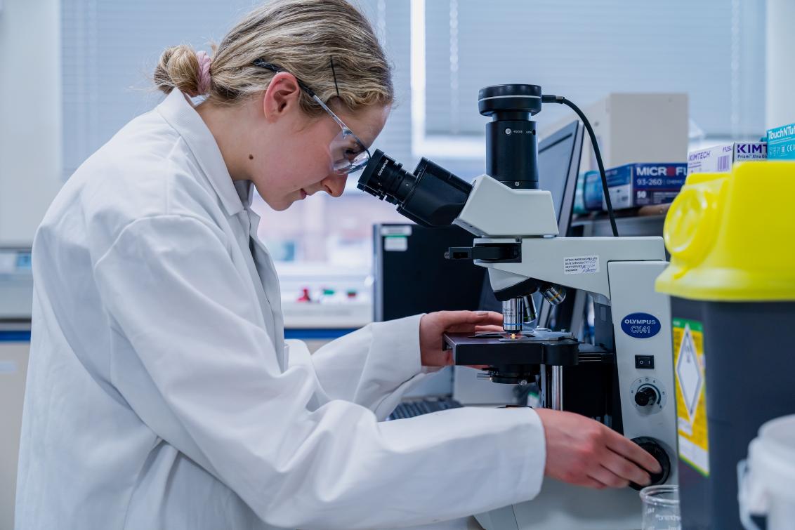 woman looking in a microscope