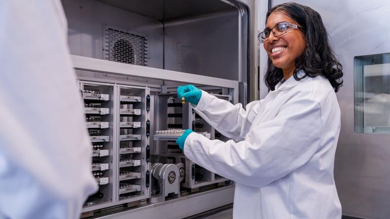 Female scientist doing science wearing blue gloves.