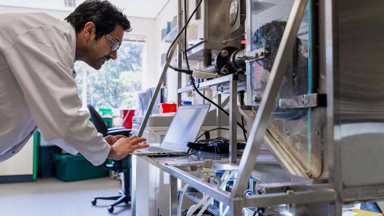Scientist looking at a laptop in a lab.